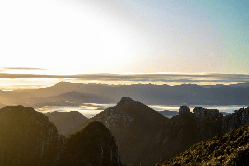A coastal landscape of mountains and sea shores looking to a horizon representing higher ground thinking for decision making, delegation and strategic thinking.